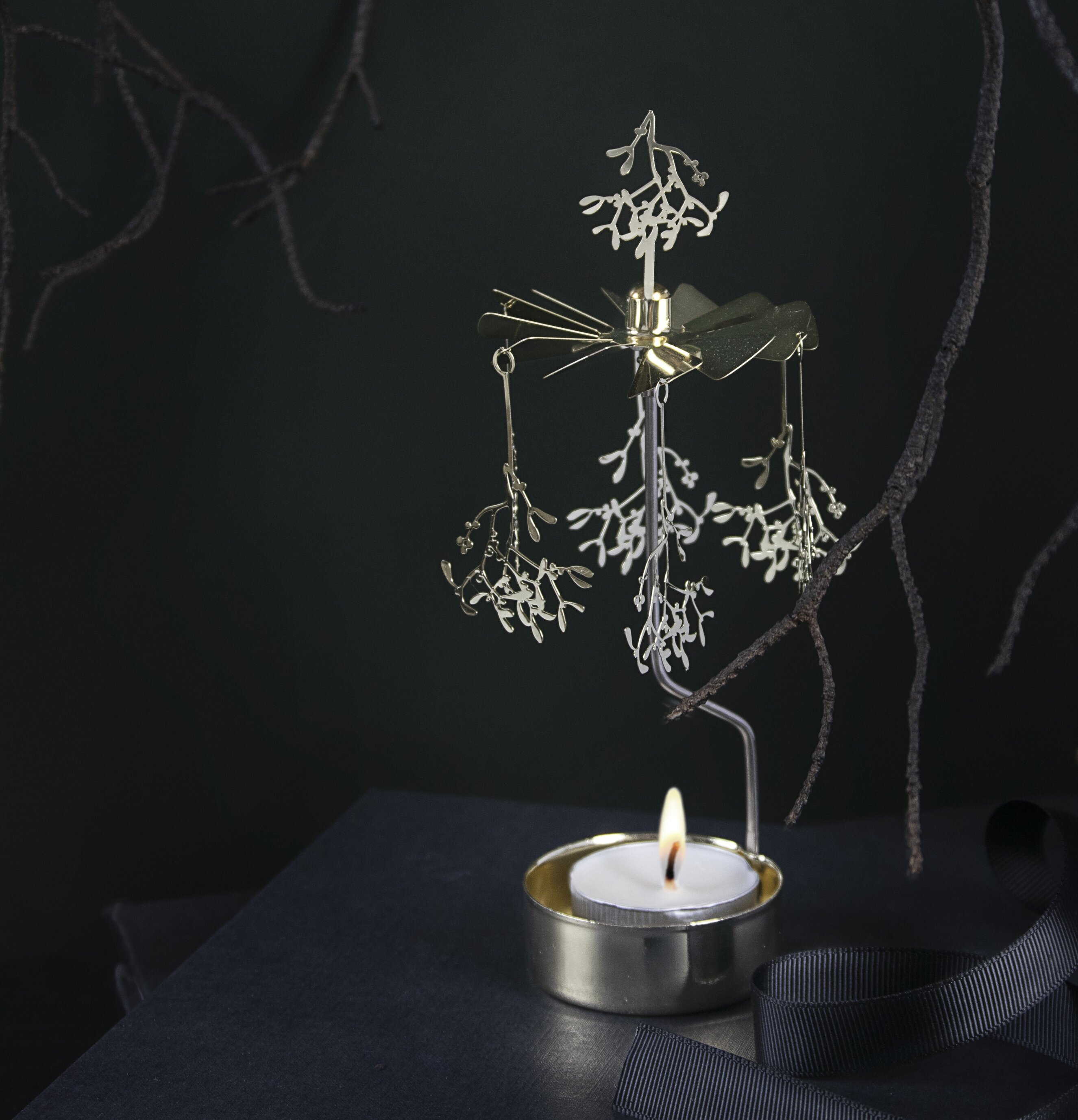 Änglaspel Mistel Guld från Pluto Produkter på en mörk bok